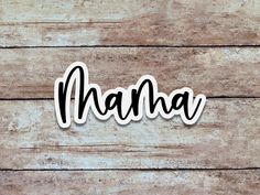 the word mama spelled in black ink on a wooden background