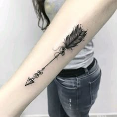 a woman's arm with a feather and arrow tattoo on the left inner forearm