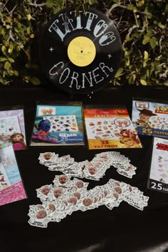 a table topped with lots of cards and stickers next to a record player's disc