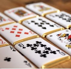 playing cards are arranged in rows on a wooden table, with gold trimmings