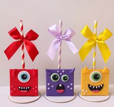 three little bags with fake eyes and bows on them, each decorated to look like monsters