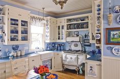 a kitchen with blue and white decor on the walls