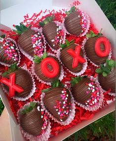 a box filled with chocolate covered strawberries in the shape of xoxo