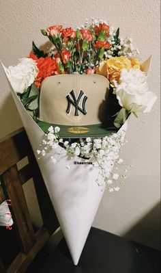 a baseball cap with flowers in it sitting on top of a table