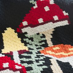 a crocheted blanket with an image of a mushroom on it