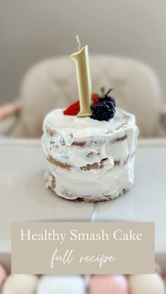 a small cake with white frosting and berries on top