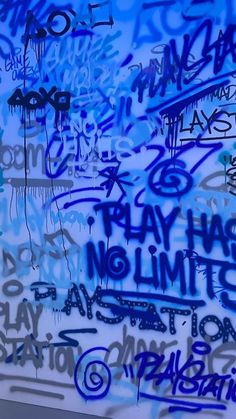 graffiti on the side of a building with blue spray paint and writing all over it