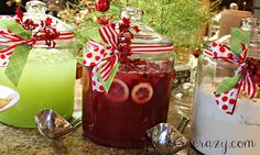 three jars filled with liquid sitting on top of a counter next to christmas decorations and spoons