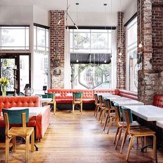 an empty restaurant with tables and couches in front of large windows that look out onto the street