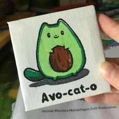 a person holding up a small card with an image of a cat on it's back