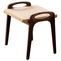 a small wooden stool with an oval handle on the back and seat, made out of wood