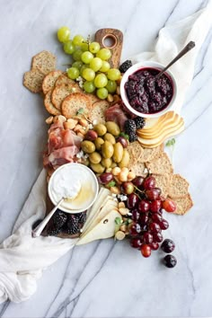 an instagram with grapes, crackers, cheese and other food items on it