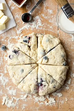 blueberry scones cut into eight slices on a cutting board with butter and jam