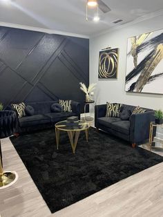 a black and gold living room with two couches, a coffee table and paintings on the wall