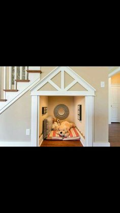 there is a dog house with two stuffed animals in it and stairs leading up to the second floor