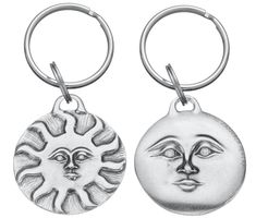 two metal key chains with sun and moon faces on them, one in the shape of a face