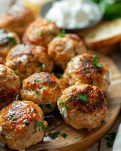 some meatballs are sitting on a wooden plate