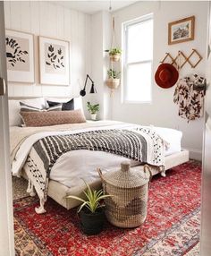 a bed sitting on top of a red rug in a bedroom next to a window