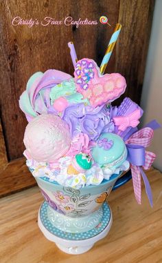 a cup filled with lots of candy and candies on top of a wooden table