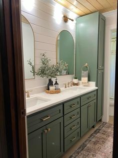 a bathroom with two sinks and green cabinets