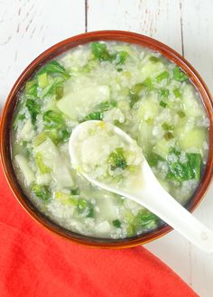 a bowl of soup with broccoli and rice in it, on top of a red napkin