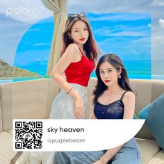 two beautiful young women sitting next to each other on top of a couch near the ocean