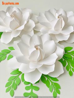 paper flowers with green leaves on the bottom and white petals on the top are cut out