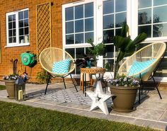 three chairs and two tables on a patio with potted plants in the foreground