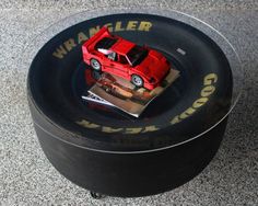 a red toy car sitting on top of a black tire