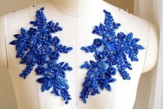 the back of a mannequin with blue beads and snowflakes on it