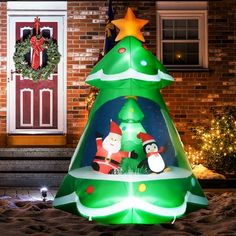 a lighted christmas tree in front of a house with decorations on the outside and inside