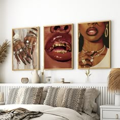 a bedroom with three paintings on the wall and two women's mouths hanging above the bed