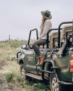 a woman sitting on the back of a green truck