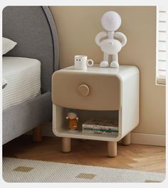 a nightstand with a lamp on top of it next to a bed