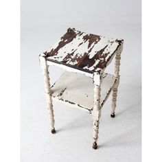 an old wooden table with white paint and brown trim on it's legs, against a white background