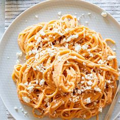 a white plate topped with pasta covered in fettuccine and parmesan cheese