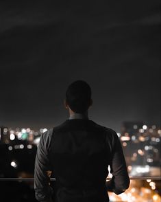 a man looking out over the city at night