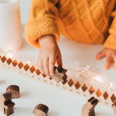 a child playing with wooden shapes on a ruler