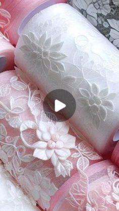 several rolls of pink and white lace with flowers on them