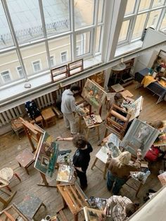 an overhead view of people painting in a room with large windows and lots of furniture