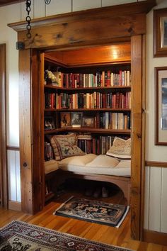 an open bookcase with lots of books on it in a living room next to a rug