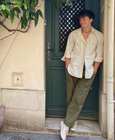 a man standing in front of a green door