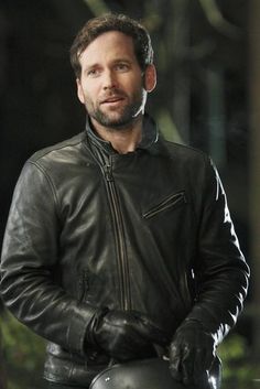 a man wearing a black leather jacket and gloves