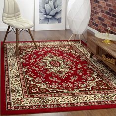 a living room area with a red rug and white chair next to a brick wall