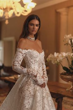 a woman in a wedding dress standing next to a table