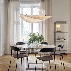 a dining room table with chairs and a chandelier hanging from it's ceiling