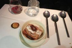 a table topped with desserts and silverware on top of a white table cloth