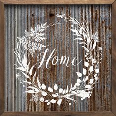 a wooden frame with the word home painted on it and a wreath drawn in white