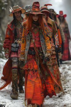 a group of people walking down a snow covered road wearing costumes and hats with feathers on them