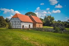 an old house sits in the middle of a grassy field